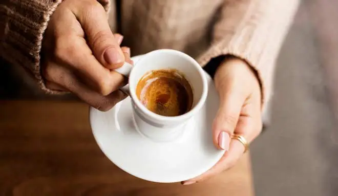 Woman holding a cup of espresso