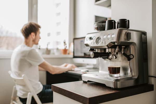 Woman using a professional coffee machine at home